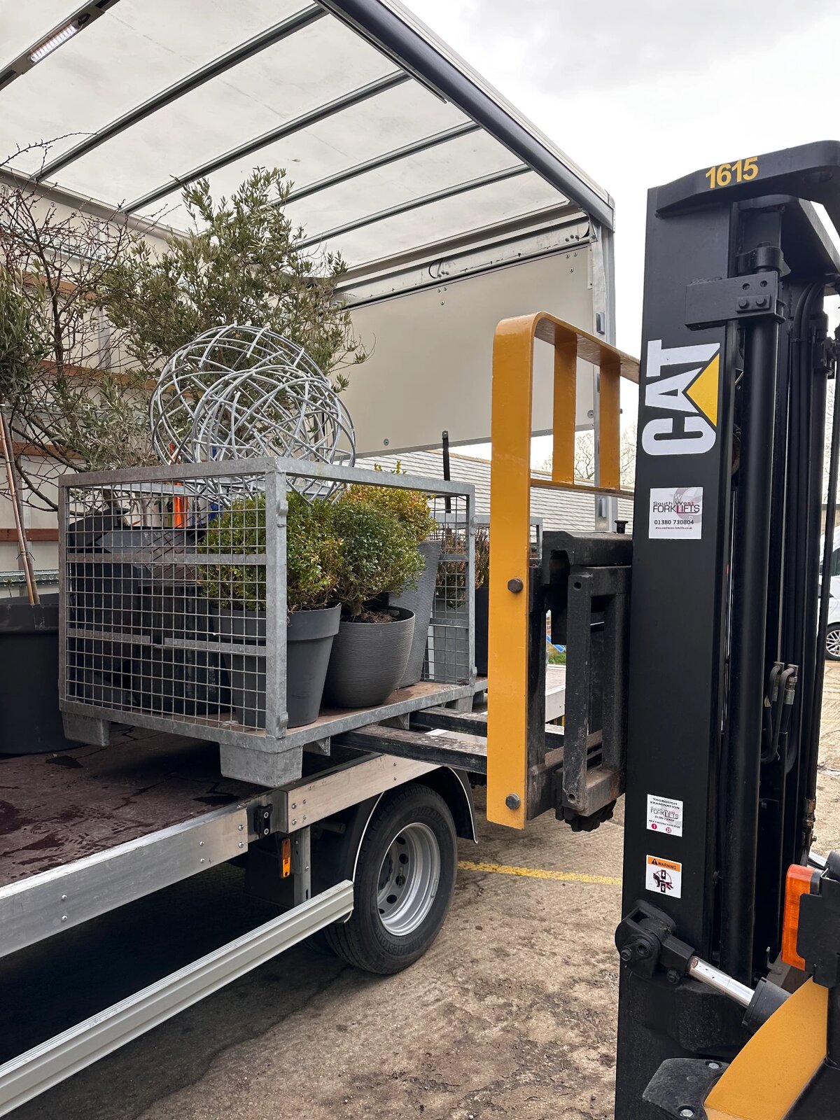 Forklift loading potted plants and garden items onto an RH curtain-side lorry