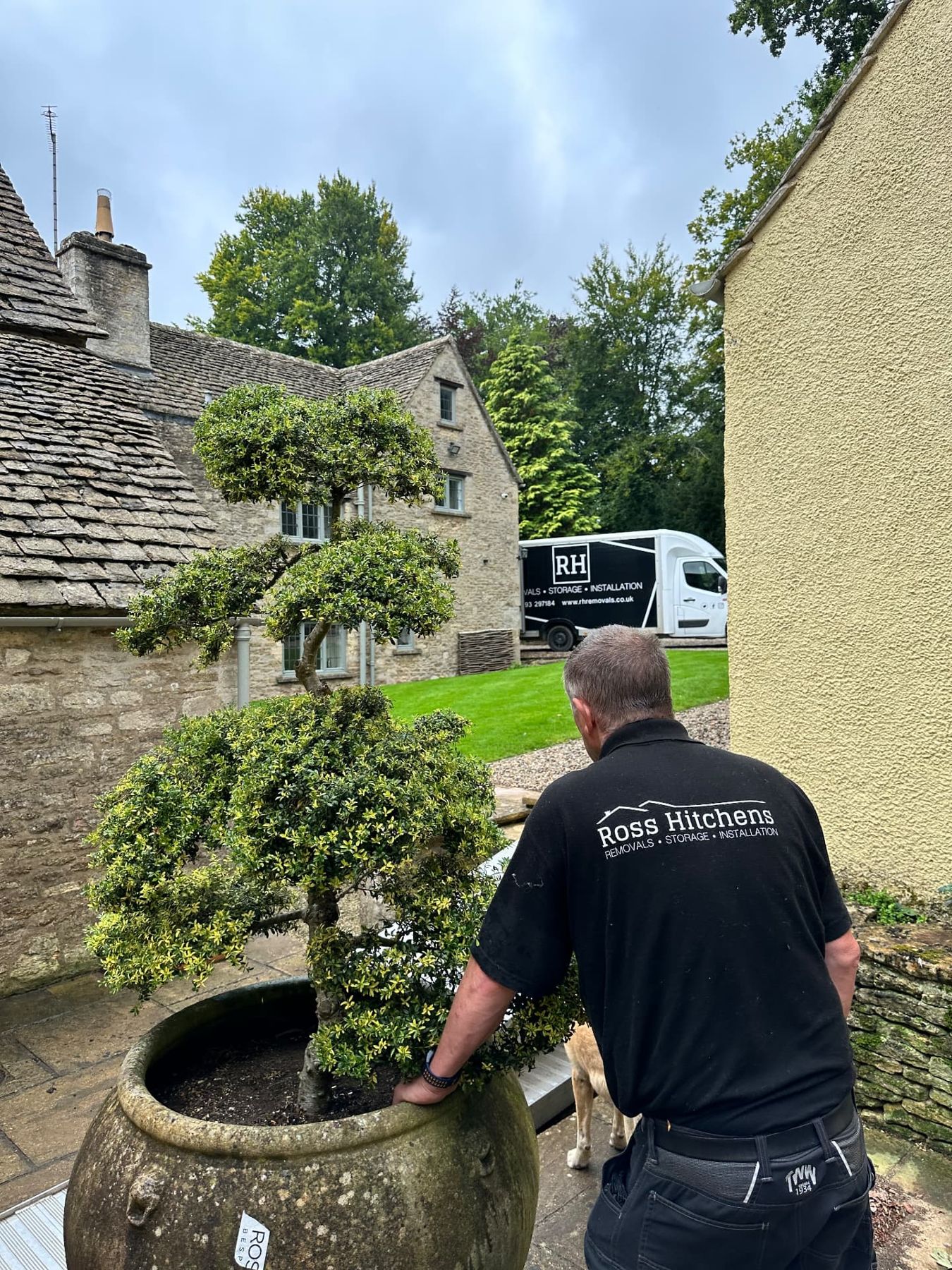 RH team moving a large planter at a Cotswold stone property
