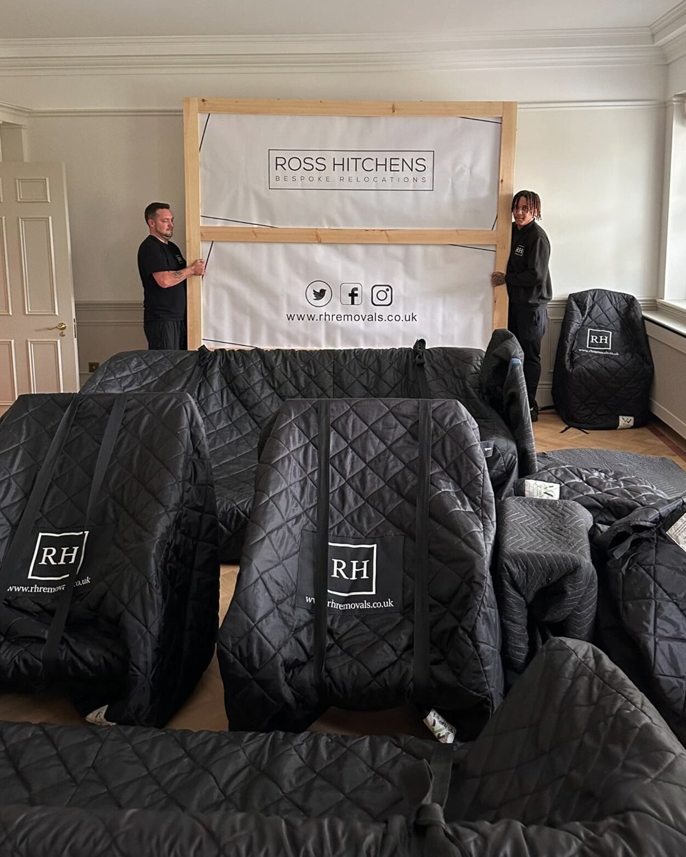 The same room after packing: furniture in RH covers and the painting going into its crate