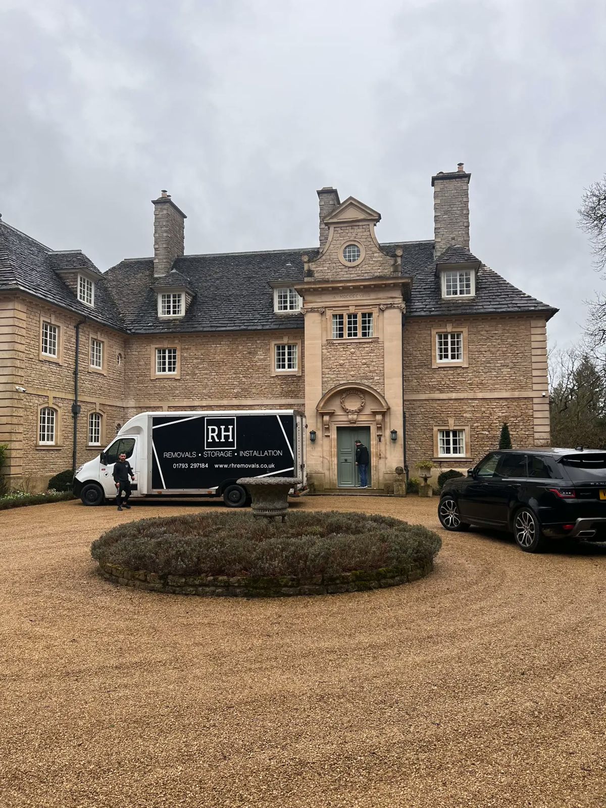 RH removal van on the drive of a Cotswold stone manor house
