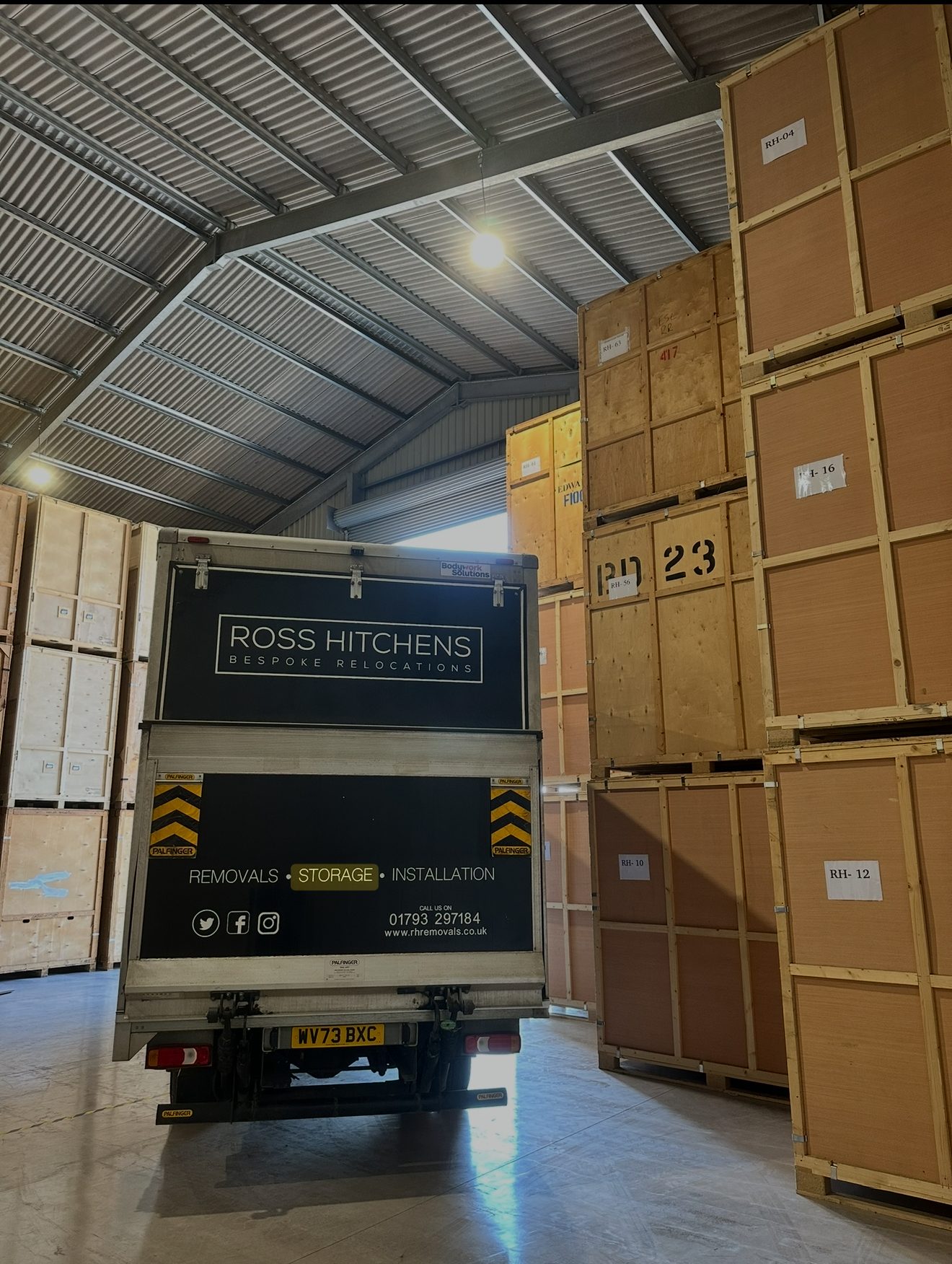 RH lorry inside the warehouse beside stacked storage containers